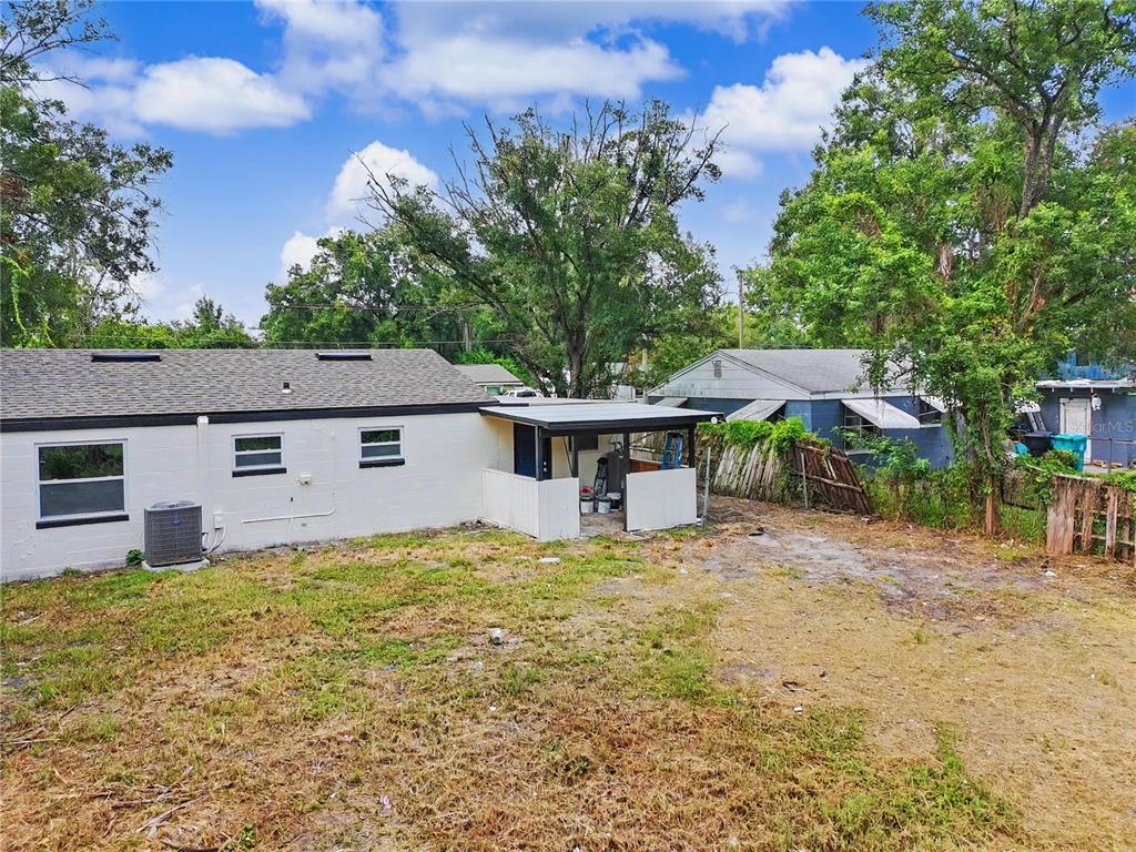 The exterior of a white house features a small covered patio and a grassy yard — 2848 W HARWOOD STREET, ORLANDO, FL