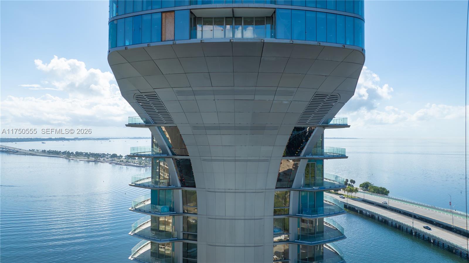 An exterior view of a modern high-rise building with curved glass balconies overlooking a bay — 175 SE 25 RD # 3902, Miami FL 33129, MIAMI, FL