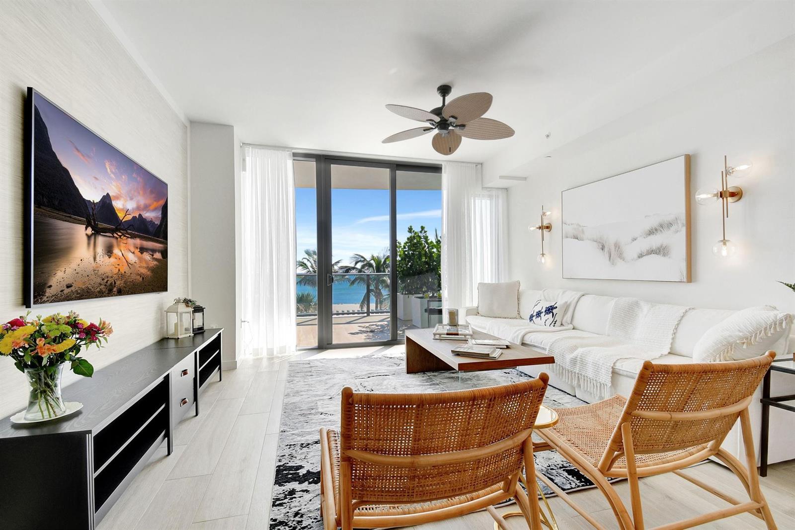 A bright living room features a white sofa, rattan chairs, and a balcony with ocean views — 1116 N Ocean Boulevard # 303, Pompano Beach FL 33062, POMPANO BEACH, FL