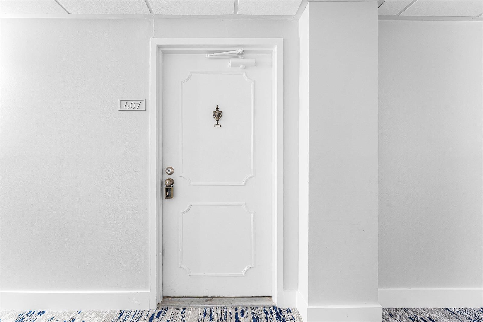 A white hotel room door labeled 407 with a peephole and electronic lock — 3215 S Ocean Boulevard # 407, Highland Beach FL 33487, HIGHLAND BEACH, FL