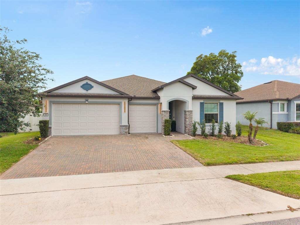 A single-story house with a paved driveway, two-car garage, and stone-accented entryway — 284 ISLAND SOUND COURT, LONGWOOD, FL