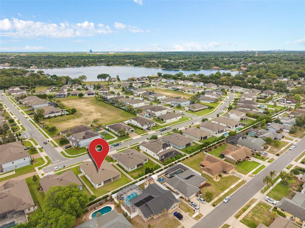 An aerial view shows a suburban neighborhood with a marked house near a lake — 284 ISLAND SOUND COURT, LONGWOOD, FL