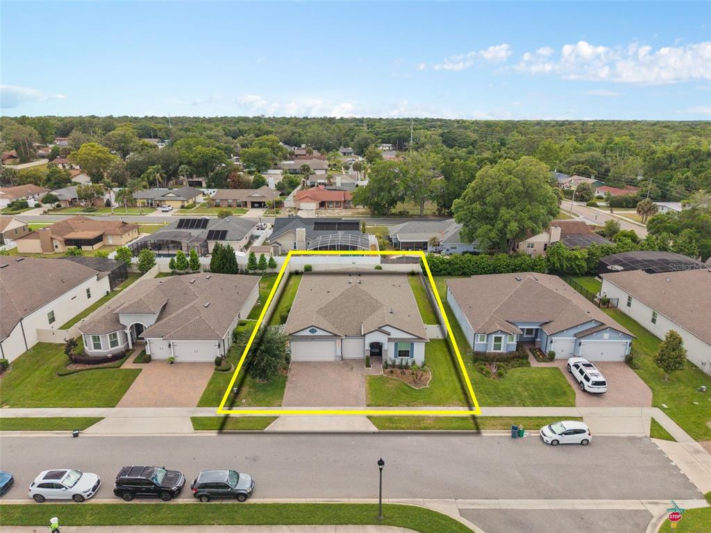 An aerial view shows a single-story suburban house with a fenced backyard and driveway — 284 ISLAND SOUND COURT, LONGWOOD, FL