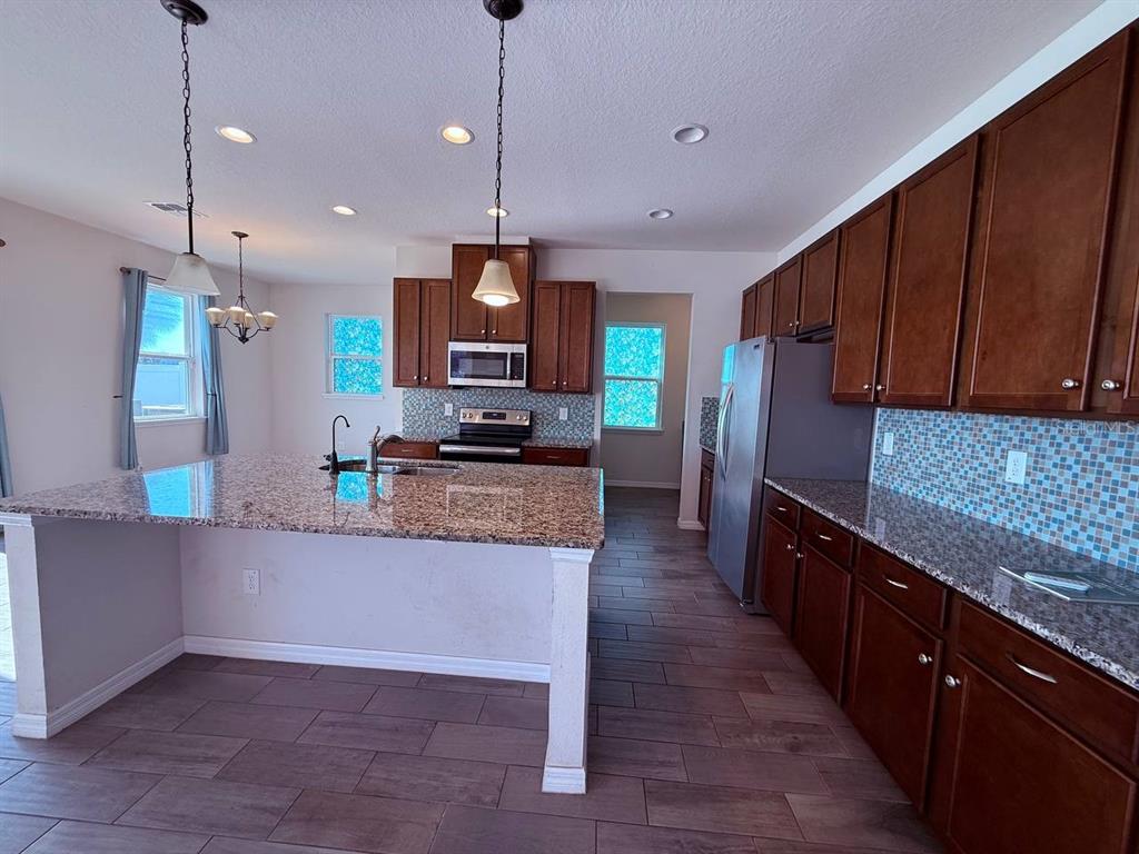 A hallway with wood-look tile flooring and a white faux-brick accent wall leads forward — 14112 POKE RIDGE DRIVE, RIVERVIEW, FL