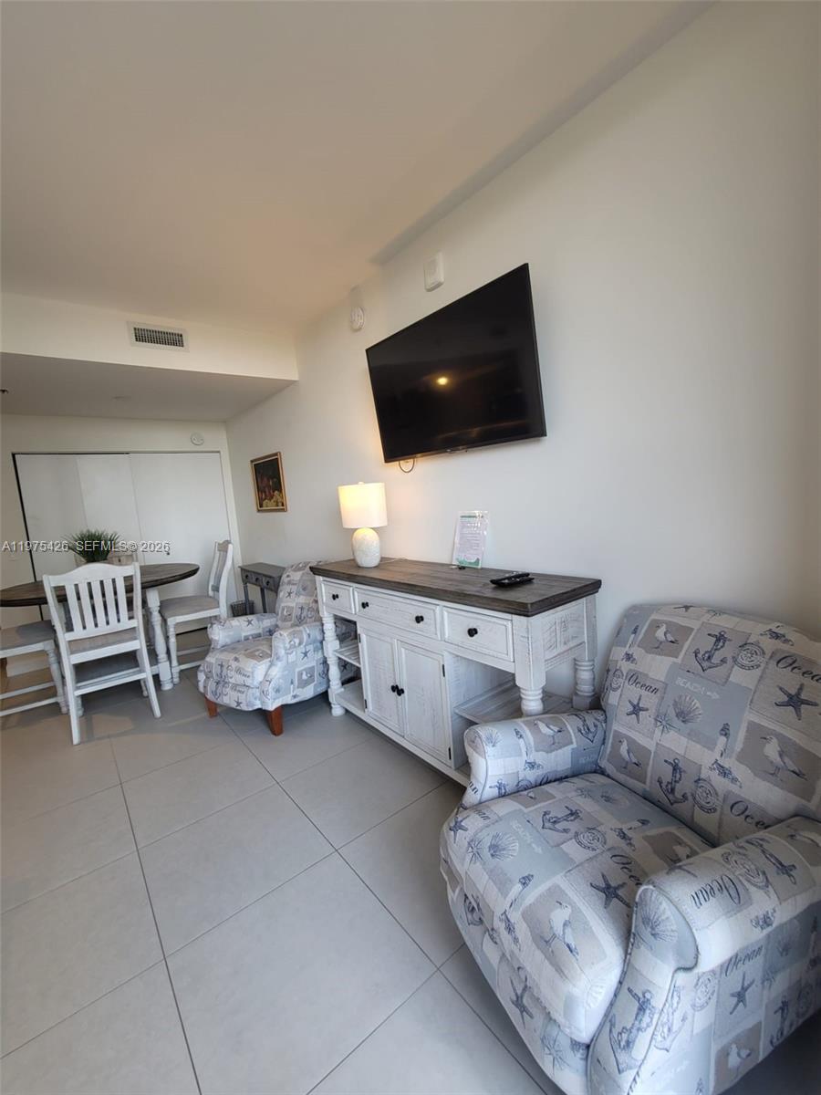 A living area features a wall-mounted television, a wooden console table, and two patterned armchairs — 5350 NW 84th Ave # 1116, Doral FL 33166, DORAL, FL