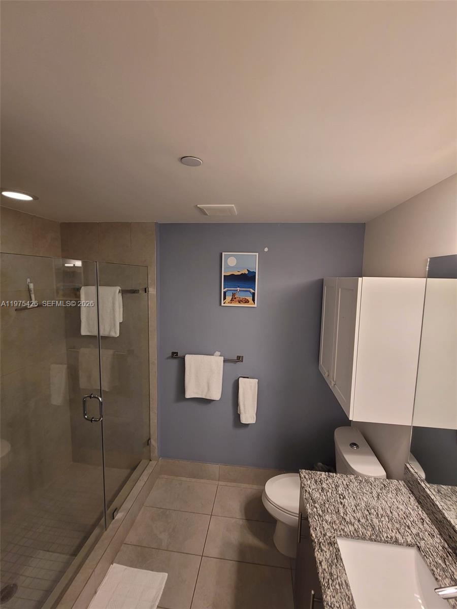 A bathroom features a glass-enclosed shower, a granite-topped vanity, and blue-painted walls — 5350 NW 84th Ave # 1116, Doral FL 33166, DORAL, FL