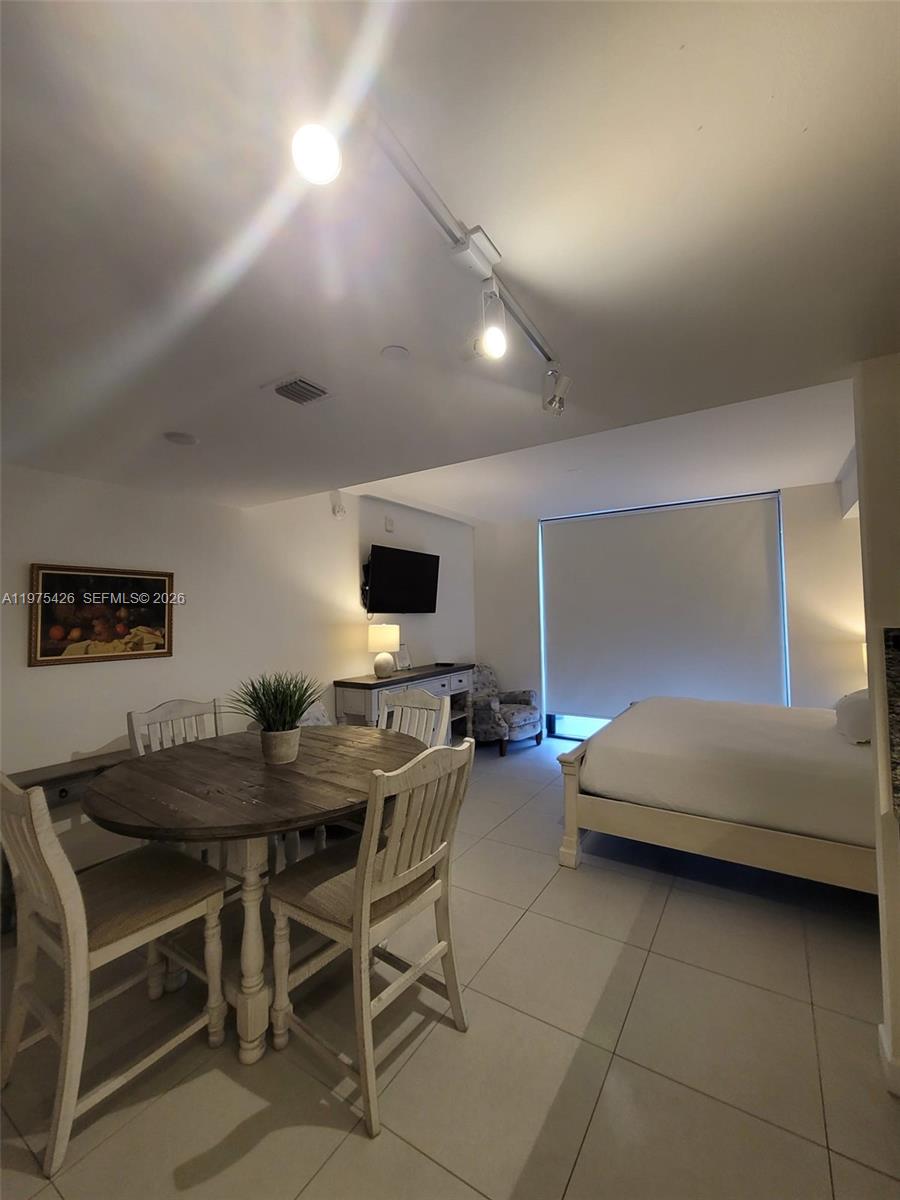 A studio apartment features a dining table, a bed, and track lighting on the ceiling — 5350 NW 84th Ave # 1116, Doral FL 33166, DORAL, FL
