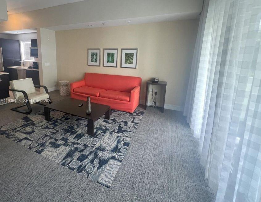 A living room features a coral sofa, a dark coffee table, and a patterned rug — 5300 NW 87th Ave # 601, Doral FL 33178, DORAL, FL