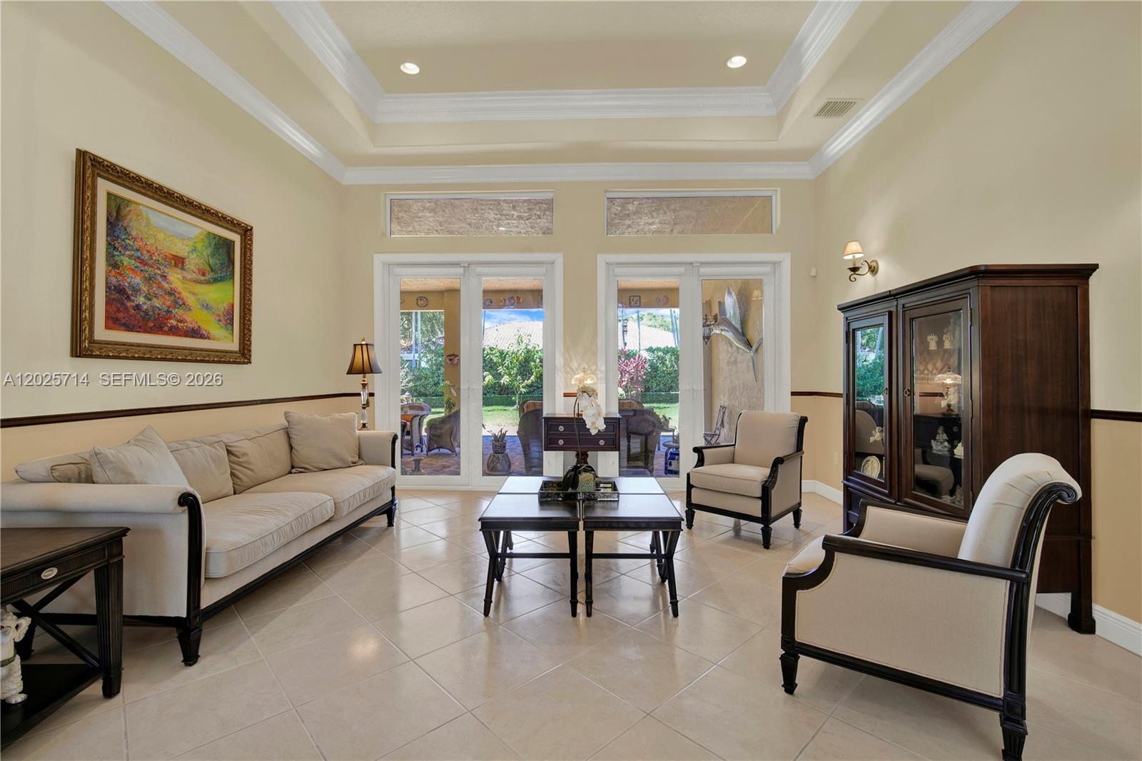 A living room features a tray ceiling, tile flooring, neutral furniture, and glass patio doors — 9563 SW 123rd Ter, Miami FL 33176, MIAMI, FL