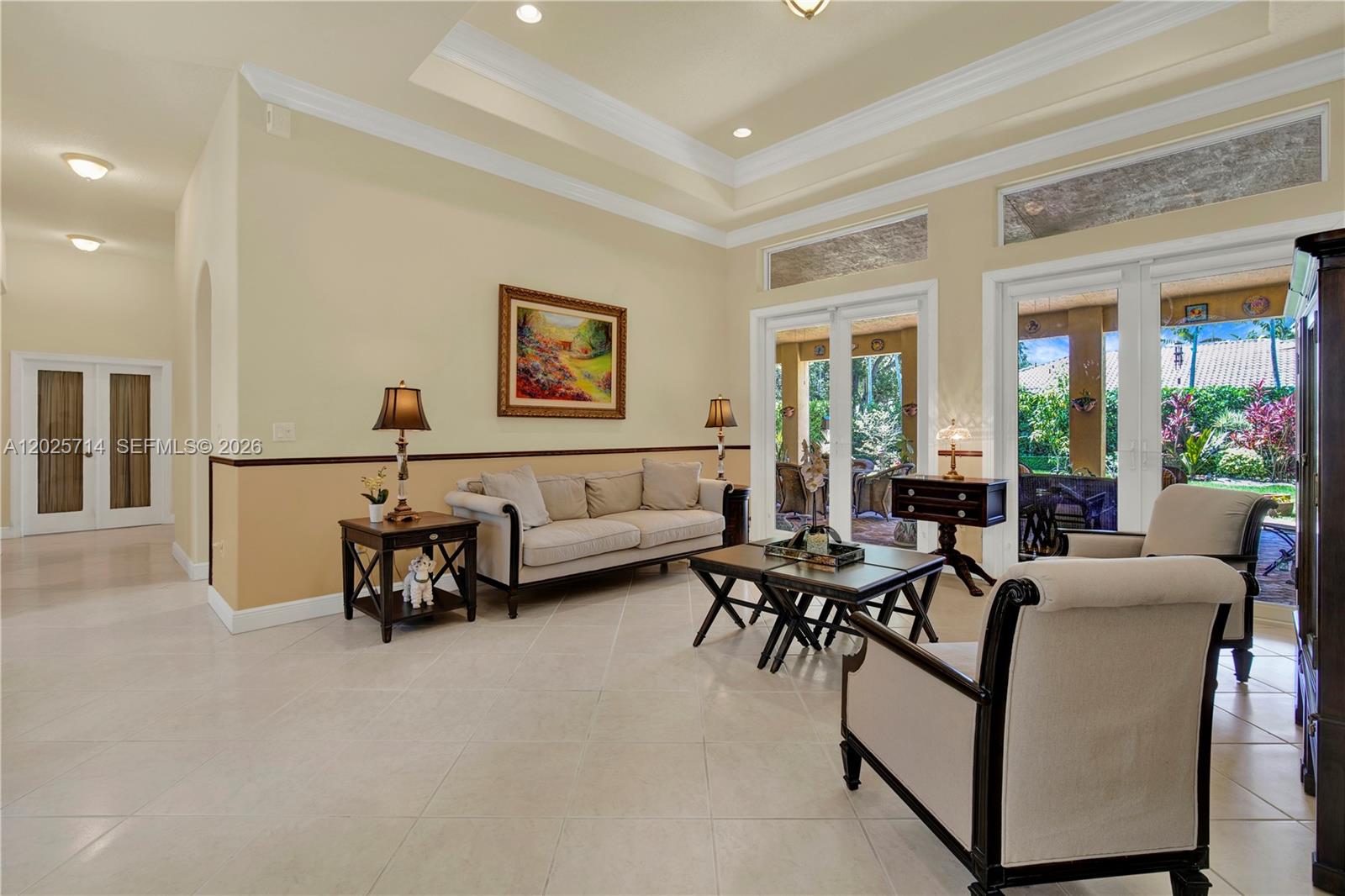 A living room features a tray ceiling, tile floors, neutral walls, and glass doors to a patio — 9563 SW 123rd Ter, Miami FL 33176, MIAMI, FL