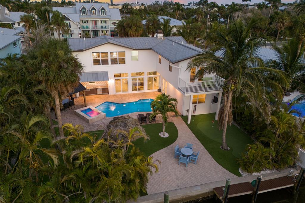 An aerial view of a two-story house with a pool, putting green, and patio area — 212 OAK AVENUE, ANNA MARIA, FL