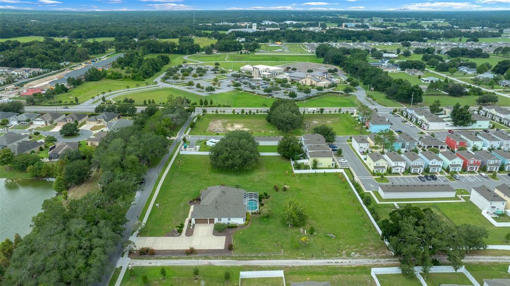 A single-story white house with a brown shingled roof and a large front lawn — 5092 NE 81ST BOULEVARD, WILDWOOD, FL