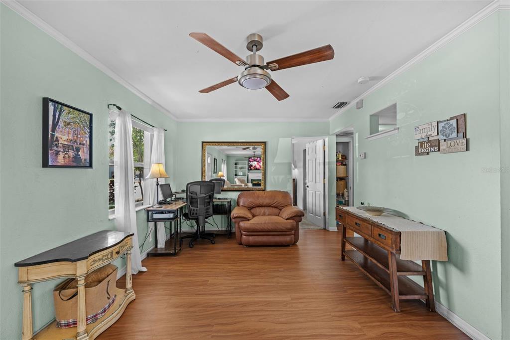 A room with light green walls, wood-look flooring, a ceiling fan, and a desk area — 6737 LAUREL STREET N, ST PETERSBURG, FL