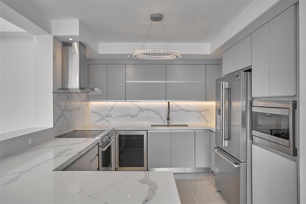 A modern kitchen features gray flat-panel cabinets, stainless steel appliances, and white marble-patterned quartz countertops — 405 CALLE INGENIERO JUAN B RODRIGUEZ UNIT 1702, SAN JUAN, PR
