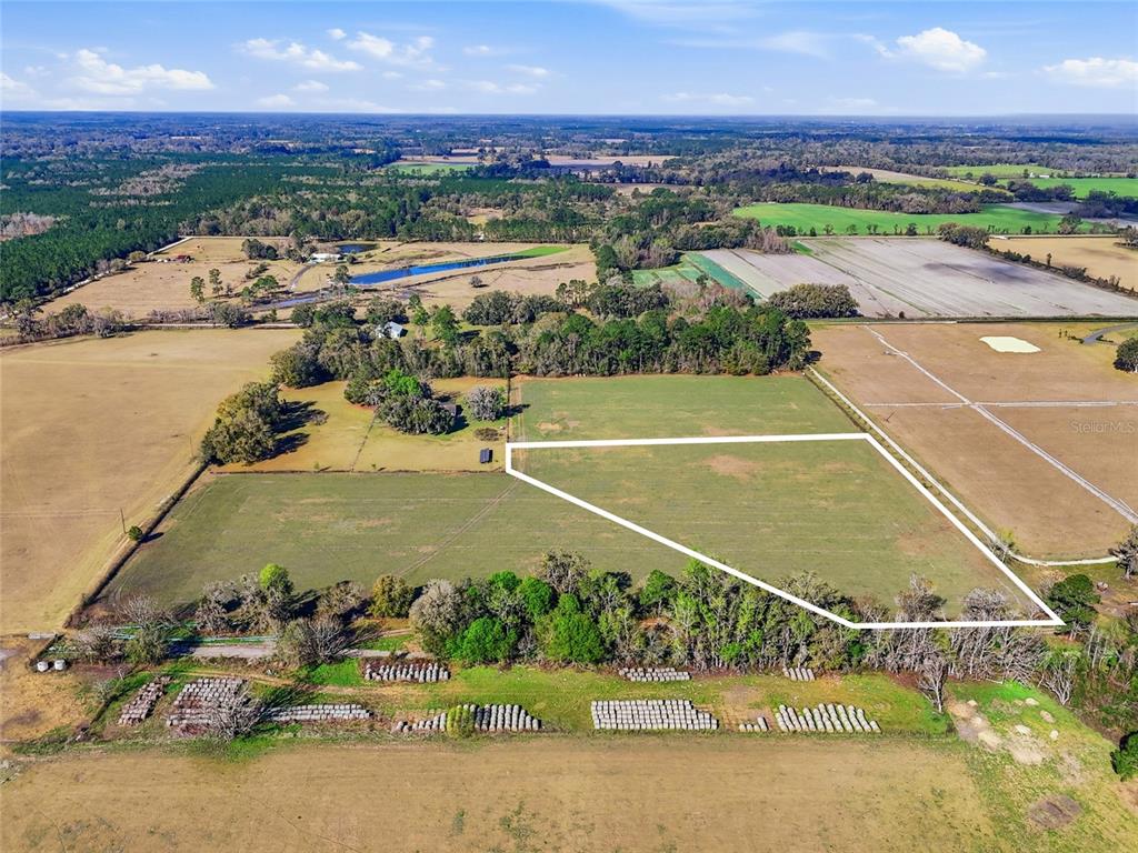 An aerial view shows a large, fenced-in pasture with a white outline highlighting the property — NW COUNTY RD 239, ALACHUA, FL