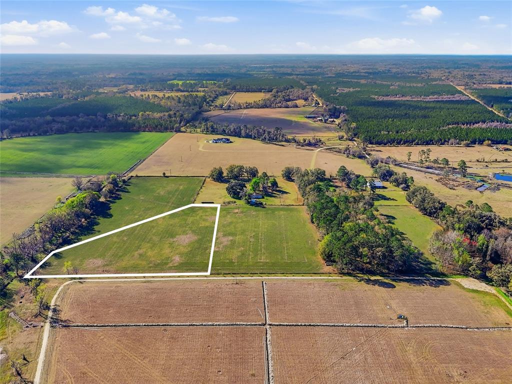 An aerial view shows a large, fenced plot of land outlined in white amidst fields — NW COUNTY RD 239, ALACHUA, FL