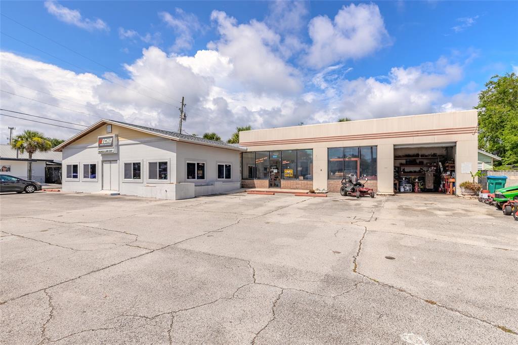 A commercial building with a gray office section and a tan service bay with parking — 600 N DIXIE FREEWAY, NEW SMYRNA BEACH, FL