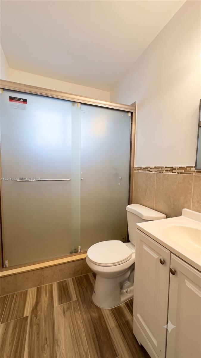 A bathroom features a walk-in shower with frosted glass doors, a toilet, and a vanity — 120 NE 55th St # 4, Miami FL 33137, MIAMI, FL