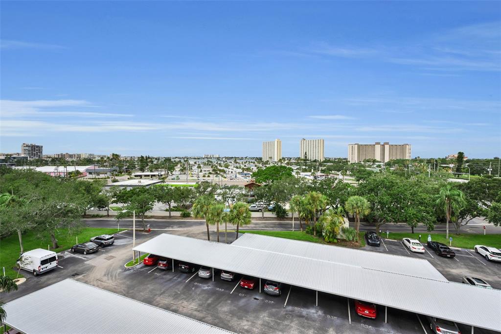An elevated view of a parking lot with covered carports and surrounding trees and buildings — 1324 PASADENA AVENUE S UNIT 605, ST PETERSBURG, FL