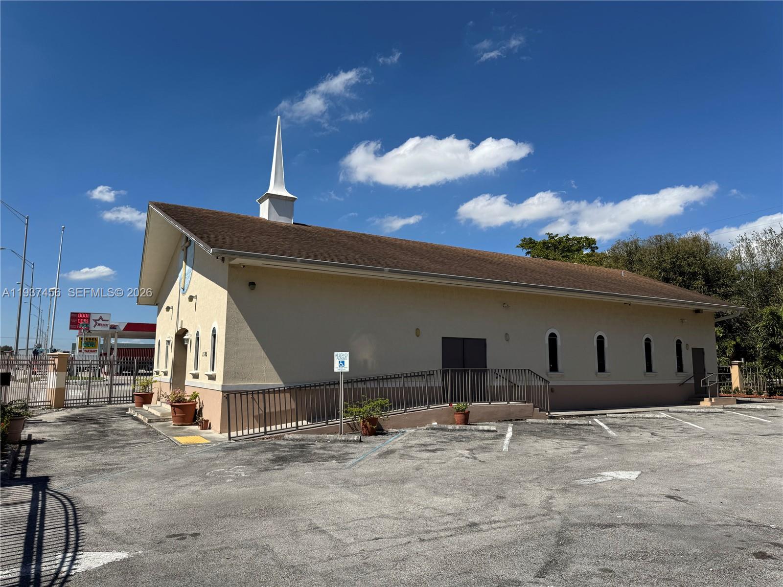 A beige church building with a steeple and a wheelchair ramp sits in a parking lot — 1595 NW 119th St, North Miami FL 33167, NORTH MIAMI, FL