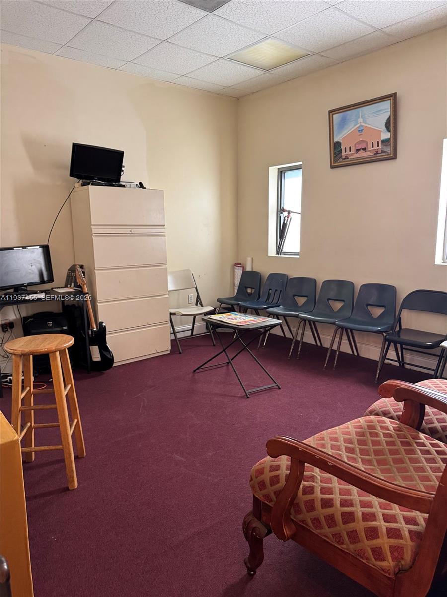 A room with maroon carpeting, a tall filing cabinet, several chairs, and a small table — 1595 NW 119th St, North Miami FL 33167, NORTH MIAMI, FL