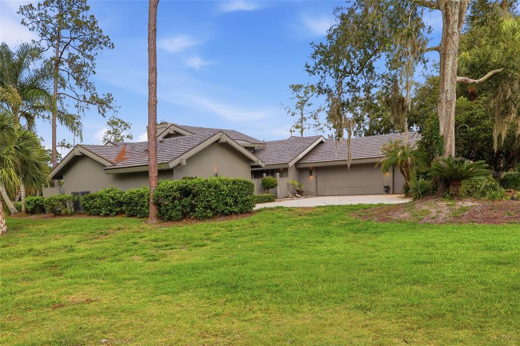 A single-story house with a gray exterior, a tiled roof, and an attached garage — 5434 KEMKERRY ROAD, WESLEY CHAPEL, FL