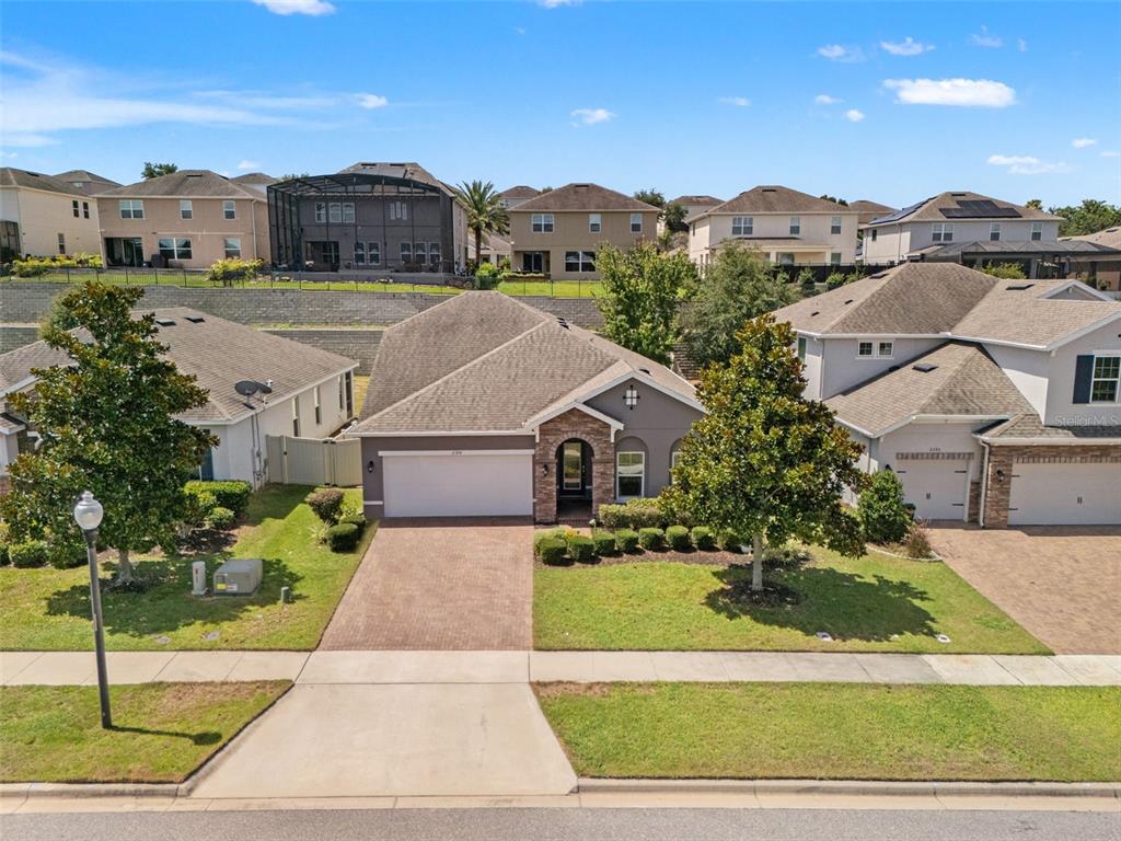 A single-story suburban house with a brick driveway, two-car garage, and stone-accented entryway — 2394 HASTINGS BOULEVARD, CLERMONT, FL