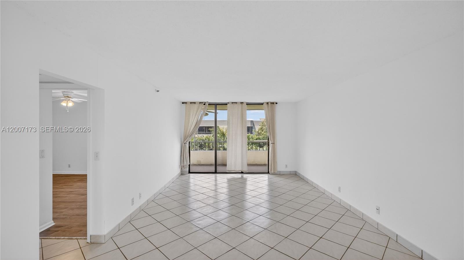 An empty room with white walls, diagonal tile flooring, and a sliding glass door — 1850 Homewood Blvd # 5010, Delray Beach FL 33445, DELRAY BEACH, FL