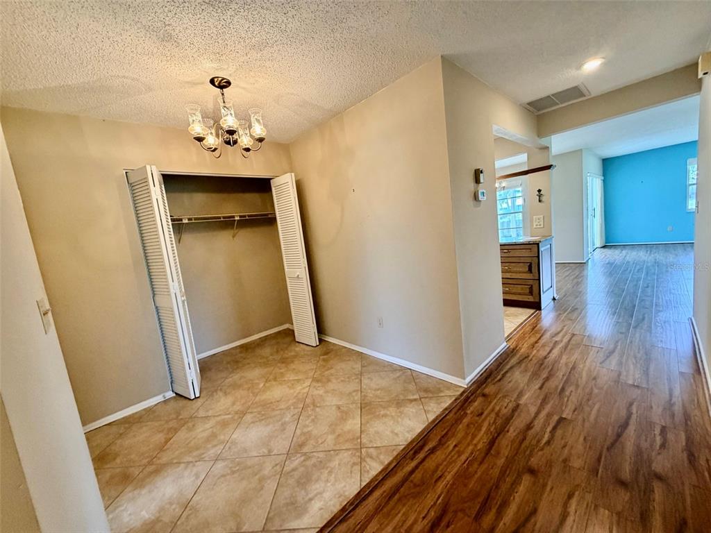 An interior view showing a tiled entryway with a closet and wood-look flooring beyond — 7302 9TH AVENUE W UNIT 7302, BRADENTON, FL