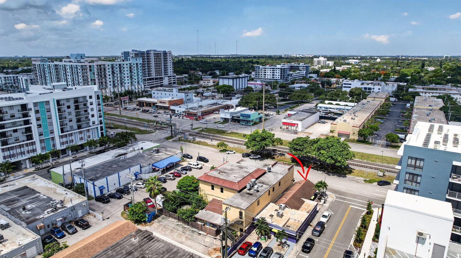 An aerial view shows a multi-story building with a brown roof and surrounding urban infrastructure — 2040 Polk Street, Hollywood FL 33020, HOLLYWOOD, FL