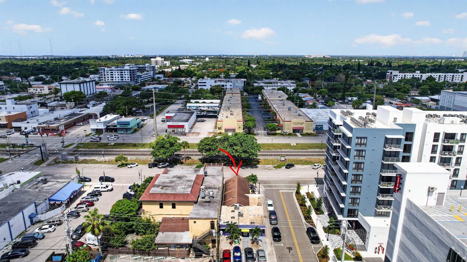 An aerial view shows a commercial building with a brown roof near a railroad track — 2040 Polk Street, Hollywood FL 33020, HOLLYWOOD, FL