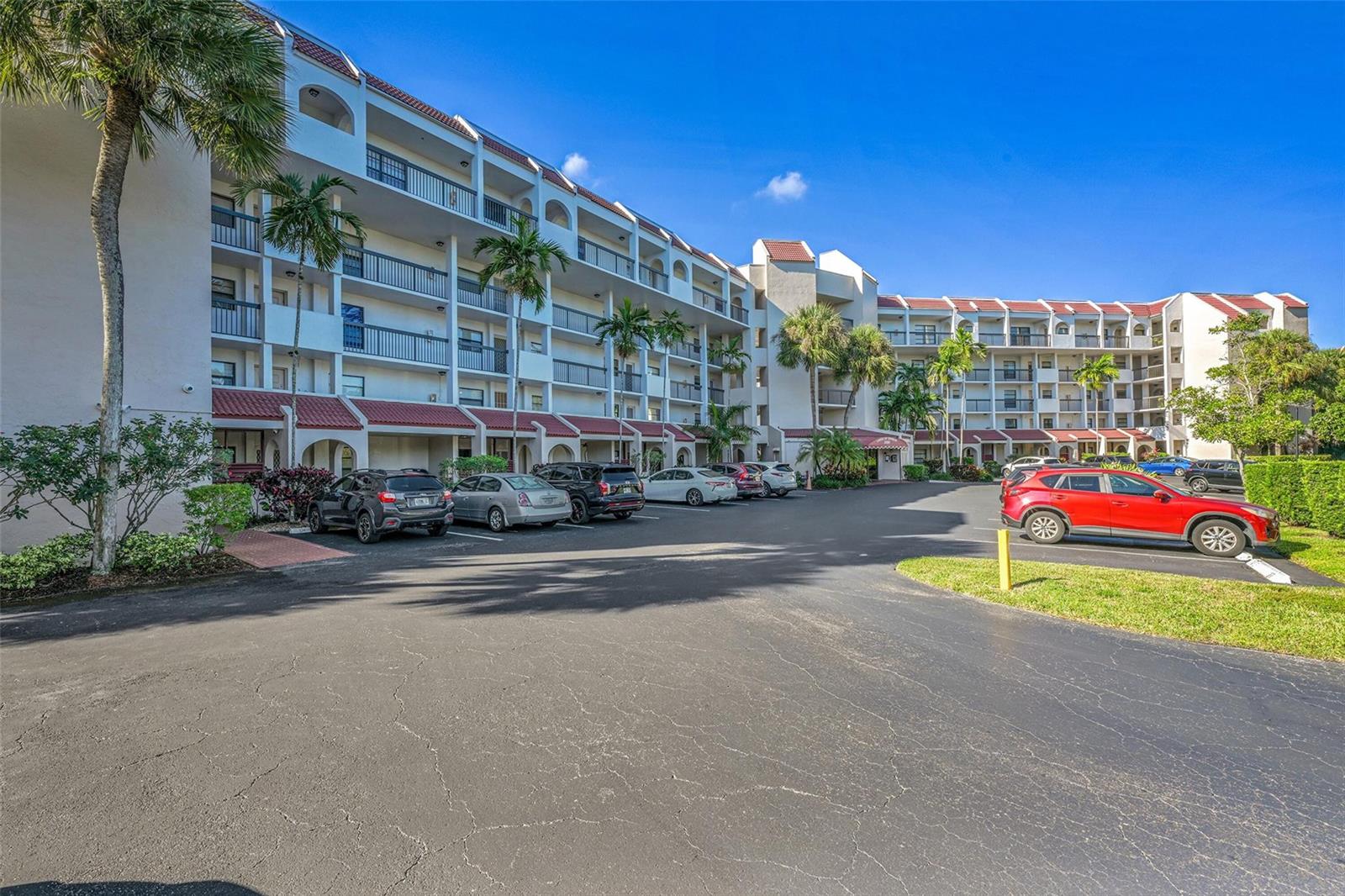 A multi-story apartment building with balconies and a parking lot in the foreground — 3591 Environ Boulevard # A305, Lauderhill FL 33319, LAUDERHILL, FL