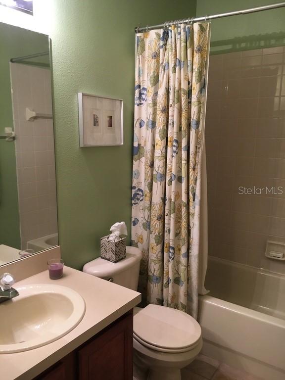 A bathroom features a vanity with a sink, a toilet, and a floral shower curtain — 6448 OSPREY LAKE CIRCLE, RIVERVIEW, FL