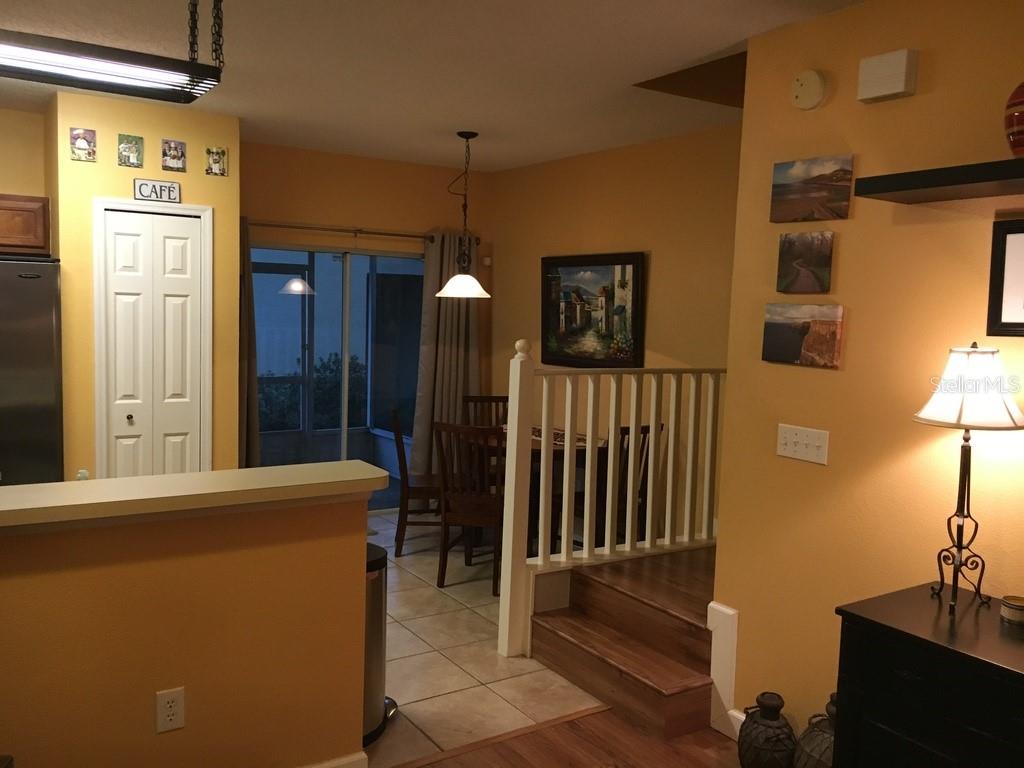 A dining area with a wooden staircase, yellow walls, and a sliding glass door — 6448 OSPREY LAKE CIRCLE, RIVERVIEW, FL