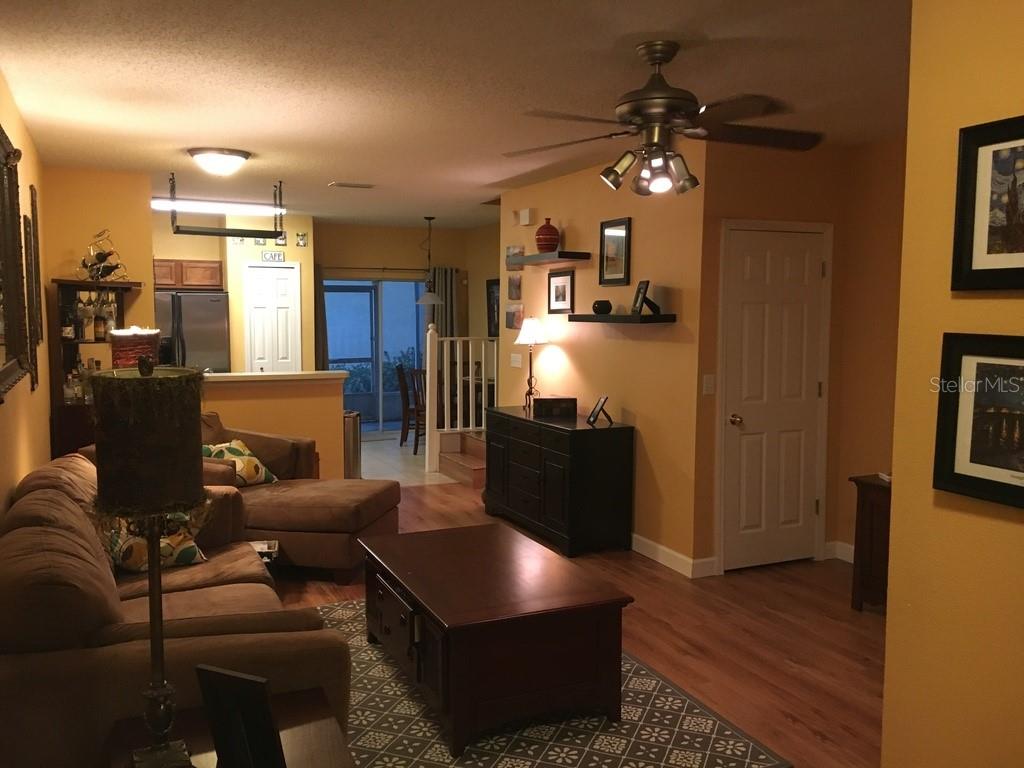 A living room with brown furniture, a ceiling fan, and a view into the kitchen — 6448 OSPREY LAKE CIRCLE, RIVERVIEW, FL