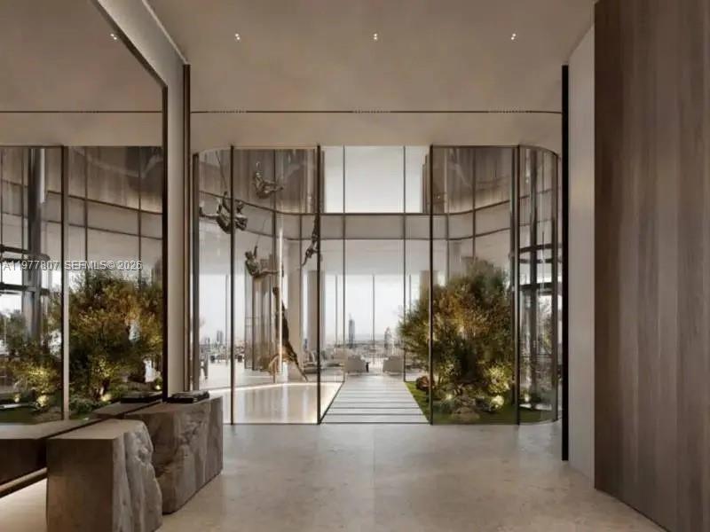 This architectural rendering shows a modern lobby with stone accents, indoor trees, and glass walls — 7A Crescent West # 00, Dubai, FL