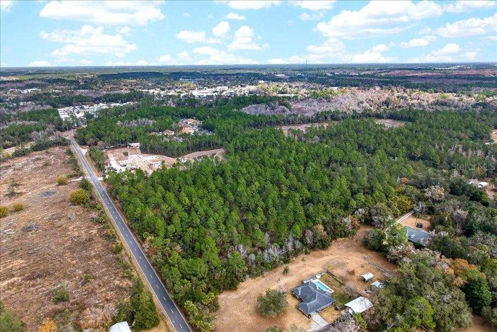 An aerial view shows a wooded lot bordered by a road and residential properties — 0 OLD HAW CREEK ROAD, BUNNELL, FL