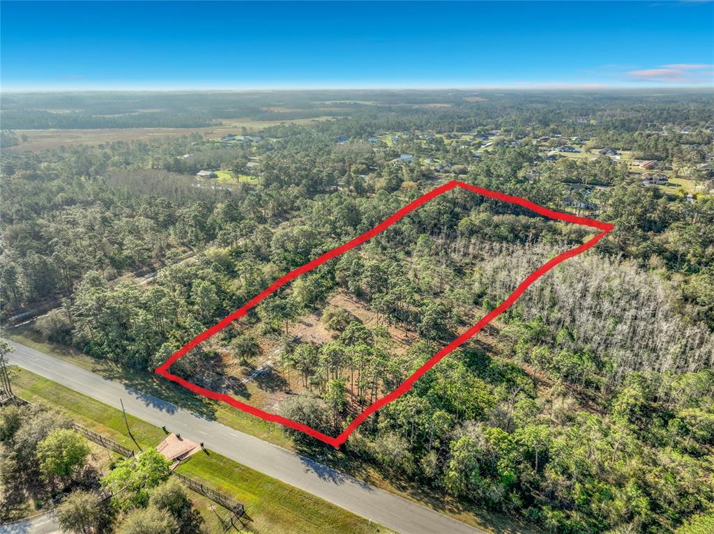 An aerial view shows a rectangular plot of land outlined in red beside a road — QUARTERLY PARKWAY, ORLANDO, FL