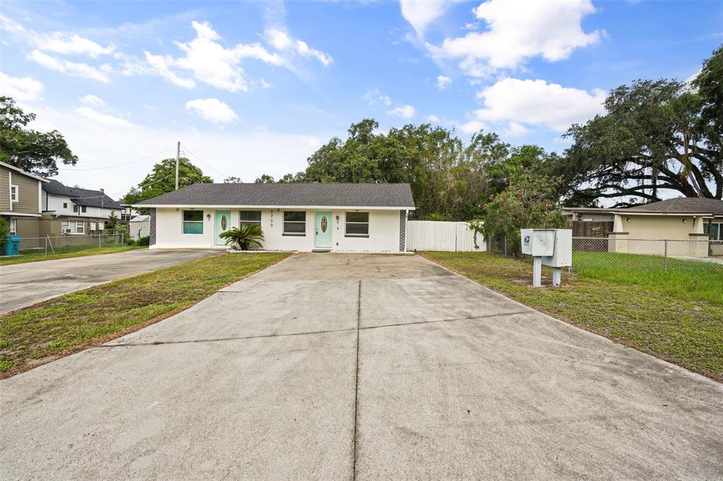 A single-story duplex with a concrete driveway and two light blue front doors — 2720 S SUNRISE COURT UNIT 2, ORLANDO, FL