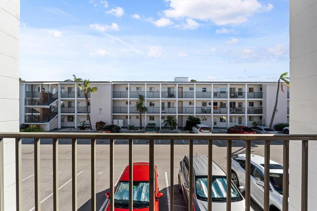 A view from a balcony overlooking a parking lot and a multi-story apartment building — 5902 GARDEN LANE UNIT A24, BRADENTON, FL