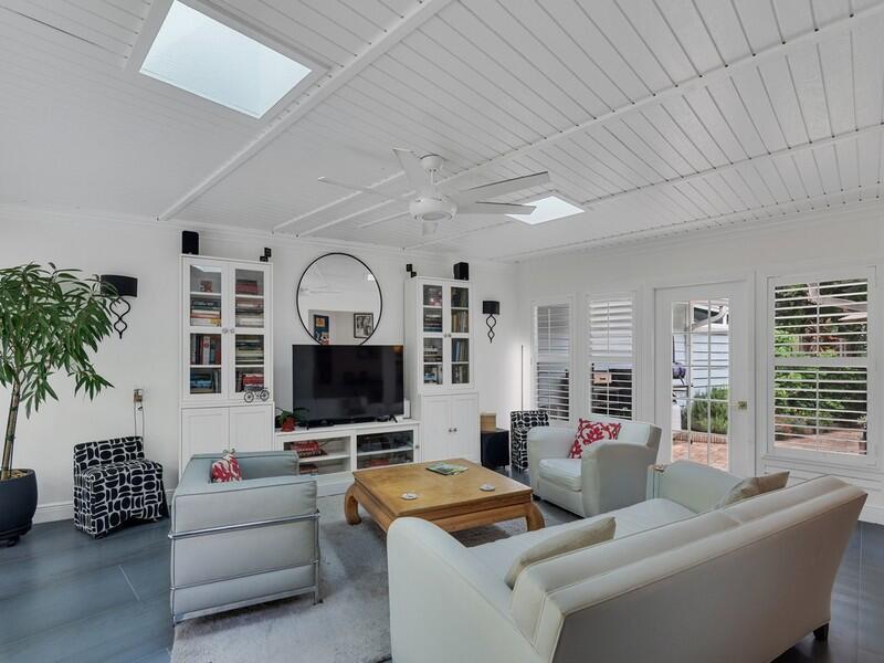 A bright living room features white paneled ceilings with skylights, a ceiling fan, and furniture — VERO BEACH, FL