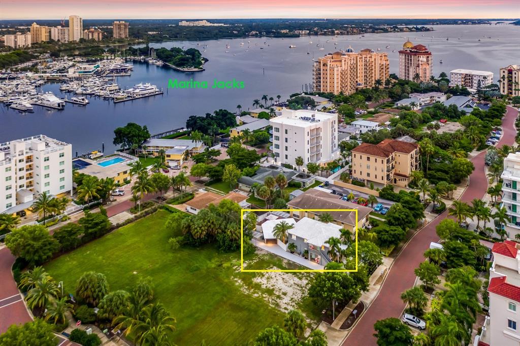 An aerial view shows a multi-story house highlighted in yellow near a marina and park — 161 GOLDEN GATE POINT, SARASOTA, FL