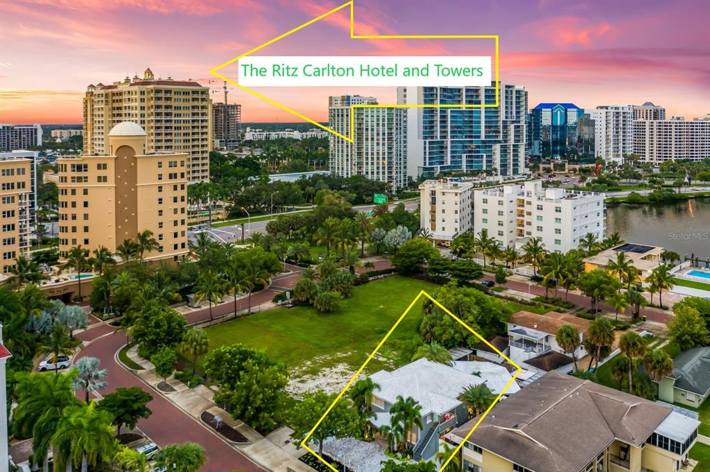 An aerial view shows a residential property in the foreground with high-rise buildings beyond — 161 GOLDEN GATE POINT, SARASOTA, FL