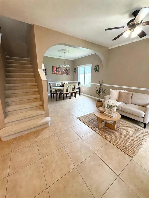 A living room with tile floors and a staircase leads to an arched dining area — 4236 BALINGTON DRIVE, VALRICO, FL