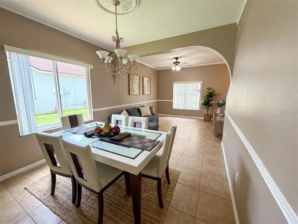 A dining room with a glass-top table leads into an adjacent living area with tile floors — 4236 BALINGTON DRIVE, VALRICO, FL