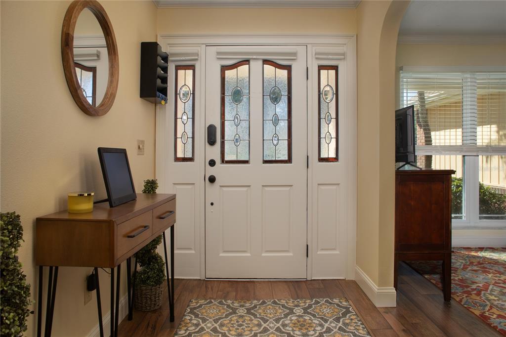 An entryway features a white front door with glass panels, a wooden console table, and flooring — 9052 PALOS VERDE DRIVE, ORLANDO, FL