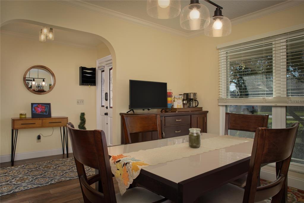A dining room features a dark wood table, matching chairs, a sideboard, and a window — 9052 PALOS VERDE DRIVE, ORLANDO, FL