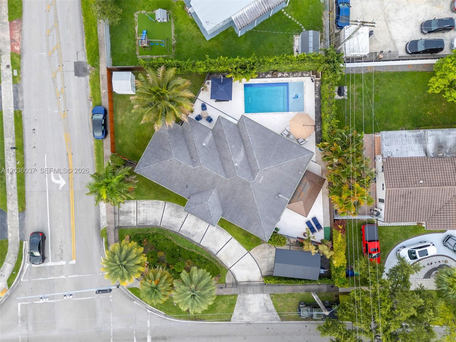 An aerial view shows a house with a swimming pool, patio, and curved driveway — 1201 SW 92nd Ave, Miami FL 33174, MIAMI, FL