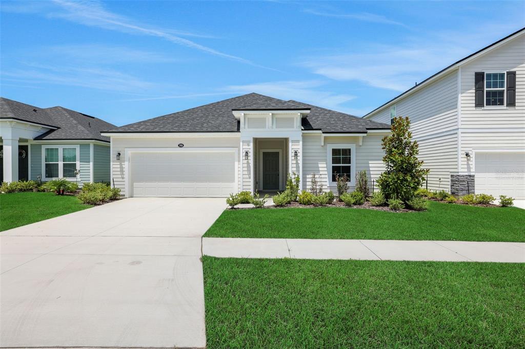A single-story house with a white exterior, a two-car garage, and a green lawn — 3906 HOLSTEIN WAY, GREEN COVE SPRINGS, FL