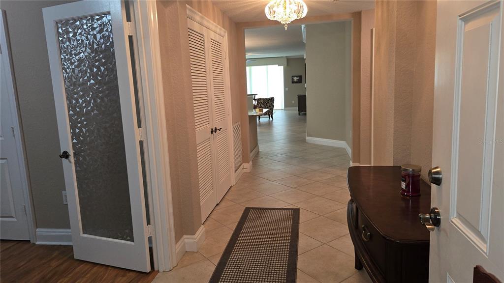 An entryway with tile flooring leads to an open living area with a chandelier — 2925 TERRA CEIA BAY BOULEVARD UNIT 2203, PALMETTO, FL